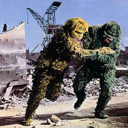 Ein riesiges grünes Monster kämpft gegen ein riesiges braunes Monster, die beiden zerstören dabei Gebäude um sie herum.