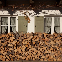 Holzlege vor einem Haus mit zwei Fenstern | Bild: BR/Herbert Ebner