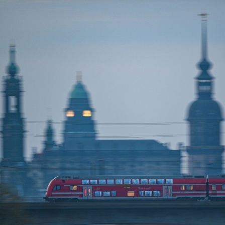 Eine S-Bahn fährt am Morgen vor der Altstadtkulisse Dresdens über die Marienbrücke. 