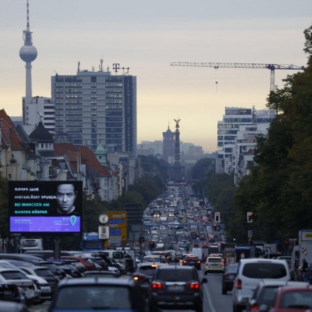 Das Bild zeigt den Berliner Kaiserdamm im Feierabendverkehr mit voll befahrenen Straßen und mit Autos eng belegten Parkflächen.