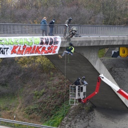 Klimaaktivisten hängen während einer Abseilaktion von einer Brücke über der Autobahn 4 neben einem Transparent mit der Aufschrift "Verkehrswende statt Klimakrise". 