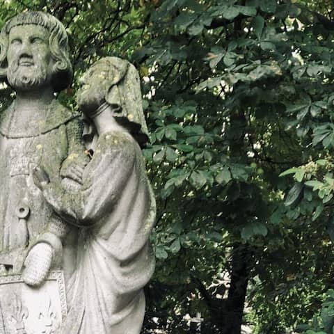 Der französische König Ludwig IX. und seine Gattin Margarete: in Stein gehauene Figuren, in den Gesichtern und auf den Schultern mit Moos überwachsen