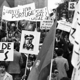Ein schwarz-weiß Foto einer Demonstration in Dortmund für die Demokatie in Portugal aus dem Jahr 1974. Menschen halten Plakate in die Höhe.