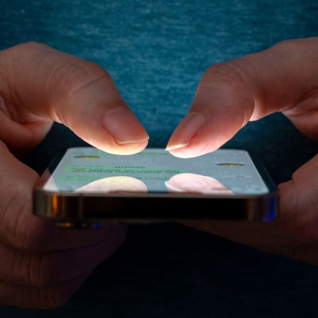 Frau tippt auf einem Smartphone
