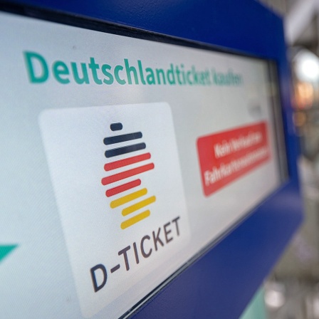 Ein Hinweis für das Deutschland-Ticket steht auf einem Fahrkartenautomaten.