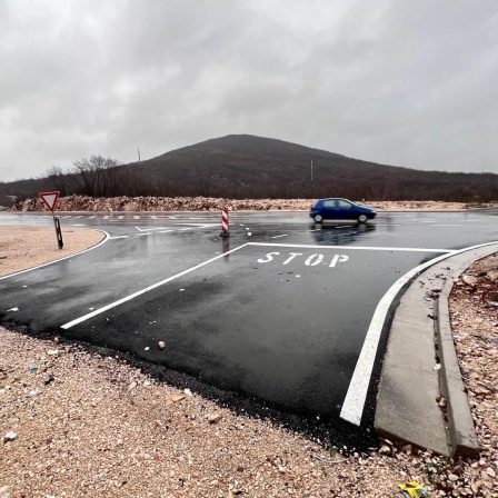 Eine geteerte Straße hört plötzlich auf und es beginnt ein Kiesweg.