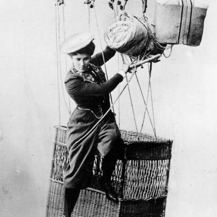 Käthe Paulus auf dem Rand eines Ballonkorbs sitzend, kurz vor ihrem Absprung mit dem Fallschirm, um 1890. 