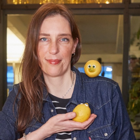 Birte Maskallis, Künstlerin, aufgenommen mit zwei ihrer Zitronen mit Glasaugen aus der "Zitronen-WG". Maskallis arangiert und fotografiert Alltagsszenen mit den präparierten Zitrusfrüchten für Kurzfilme, die sie dann auf ihrem Instagramprofil &#034;Wohnen mit Zitronen" veröffentlicht.