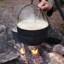 Eine Suppe kocht in einem Topf über offenem Feuer