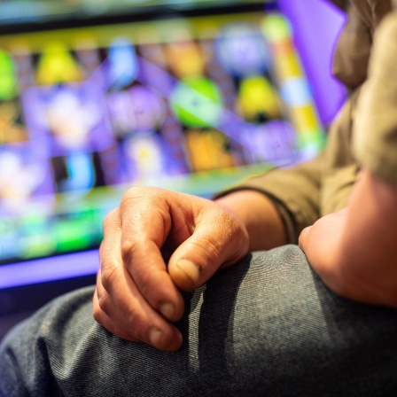Glücksspielsucht: Ein Mann sitzt vor einem Spielautomaten