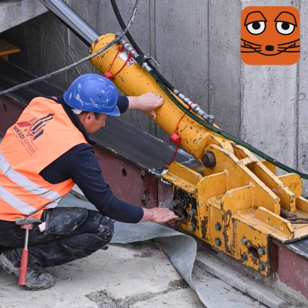 Bauarbeiter an Hydraulikzylinder, der Brücke schiebt