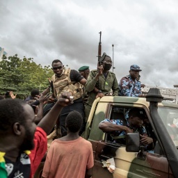 Menschen jubeln, während Sicherheitskräfte durch die Straßen der Hauptstadt Bamako in Mali fahren, 2020. Der Putsch hat den malischen Präsidenten von der Macht vertrieben.