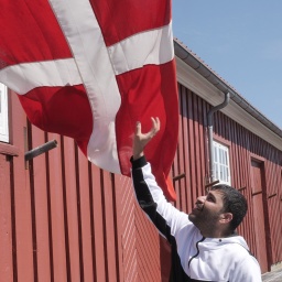 Mann greift nach dänischer Flagge
