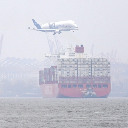 Ein Flugzeug des Typs Beluga fliegt über den Hamburger Hafen