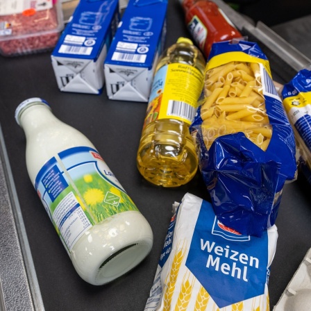Lebensmittel liegen auf einem Kassenband in einem Supermarkt