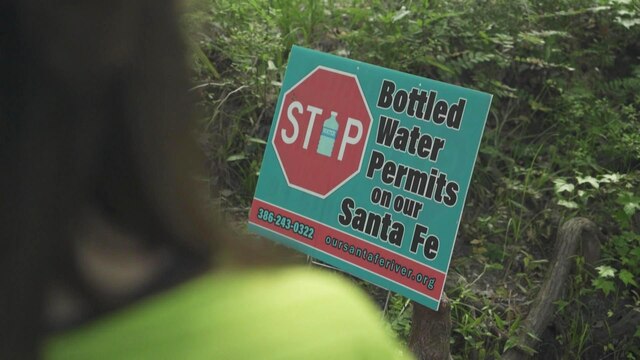 Ein Protestschild weist auf den Verkauf von Trinkwasser und seinen Folgen hin.