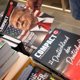 Eine Mitarbeiterin einer Bahnhofsbuchhandlung hält eine Ausgabe des Magazins "Compact", um es danach aus dem Sortiment zu nehmen. (Bild: Karl-Josef Hildenbrand/dpa)