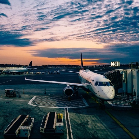 Der Flughafen von Boston im Abendlicht. Ein Flugzeug parkt an einem Eingang zum Gate.