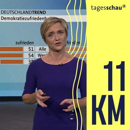 Ellen Enhi vor einer Umfragetafel für den DeutschlandTrend 2022