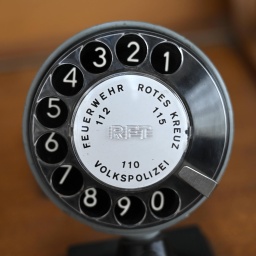 Notrufnummern der Feuerwehr und Polizei aangezeigt auf einer Wählscheibe eines Telefons aus DDR-Zeiten.