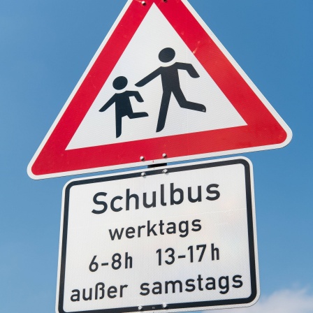 Verkehrsschild "Kinder" mit Schulbus Warnung am Straßenrand 