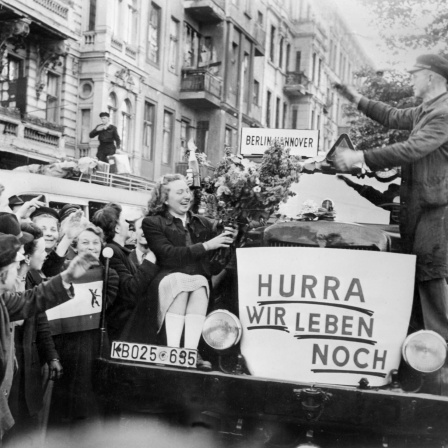 Unter dem Jubel von Bürger*innn verlassen am frühen Morgen des 12. Mai 1949 die ersten Busse Berlin in Richtung Westdeutschland
