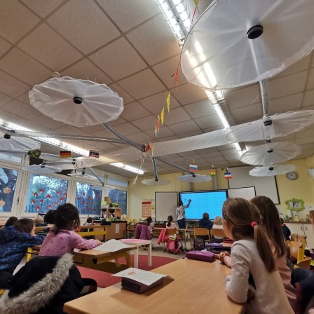 In einem Klassenzimmer ist über jedem Tisch eine selbst gebaute Abzugshaube montiert.