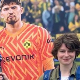 London Korrespondentin Franziska Hoppen vor einem Plakat mit Borussia Dortmund-Fußballspielern 
