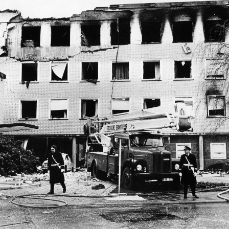 Polizei und Feuerwehr stehen im April 1975 vor dem durch eine Explosion schwer beschädigten Gebäude der deutschen Botschaft in Stockholm