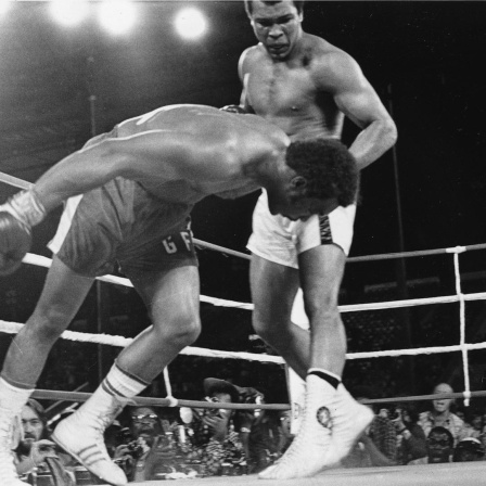 Challenger Muhammad Ali watches as defending world champion George Foreman goes down to the canvas in the eighth round of their WBA/WBC championship match in Kinshasa, Zaire, on October 30, 1974. Foreman is counted out by the referee and Ali regains the world heavyweight crown by KO in the bout dubbed 'Rumble in the Jungle.' (AP Photo)