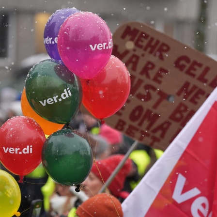 Teilnehmerinnen und Teilnehmer eines Warnstreiks im öffentlichen Dienst in Hamburg halten Luftballons mit der Aufschrift "Verdi" hoch. (Archivbild)