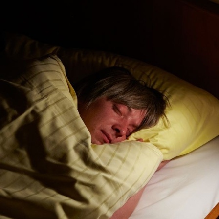 Ein Mann schläft in einem Bett