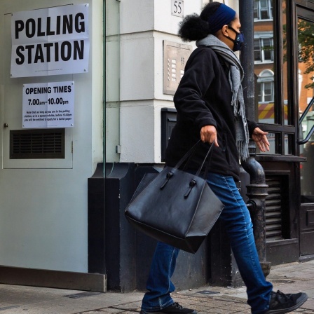 Eine Frau verlässt ein Wahllokal in London.