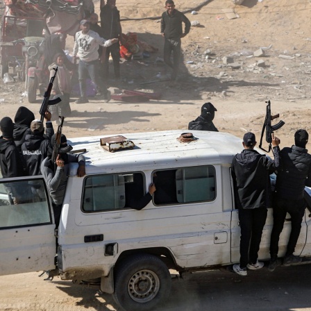 Kämpfer der Terrororganisation Hamas fahren bewaffnet in einem Jeep in Rafah im Gazastreifen (Israel).