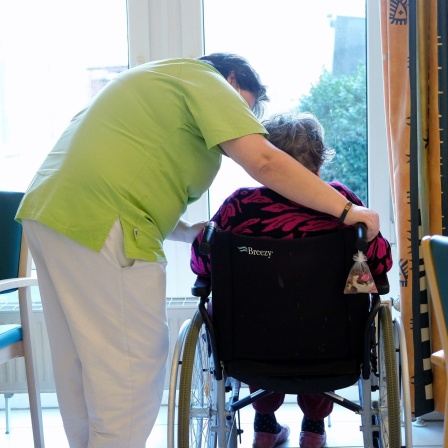 Eine Pflegerin spricht mit der Bewohnerin eines Pflegeheimes.