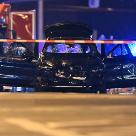 Ein Auto, mit dem ein Täter in eine Menschenmenge auf dem Weihnachtsmarkt in Magdeburg gefahren sein soll, steht mit offenen Türen in der Nähe des Tatorts. 