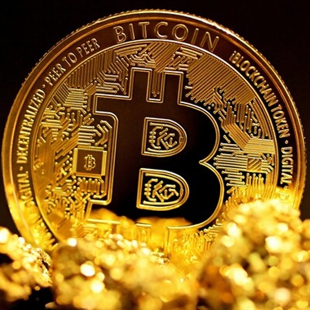 Ein Bitcoin Münze aus Gold auf einer goldfarbenen Schutzfolie