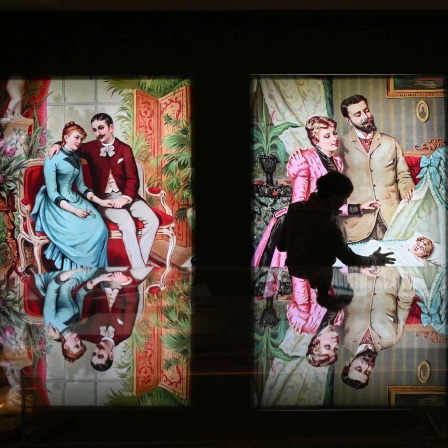 Eine Mitarbeiterin überprüft für die neue Sonderausstellung «Bilderwelt. Weltbilder» im Brandenburg-Preußen Museum (BPM) Bilderbogen mit Rollenbildern der bürgerlichen Familie (Bild: picture alliance/dpa)
