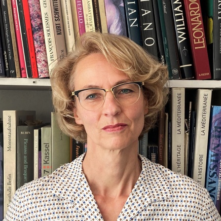 Ein Porträt von Susanne Schüssler vor einem Bücherregal.