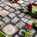 Rosen liegen auf Stolpersteinen, die an Opfer des Holocaust erinnern.