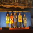 Fünf Jugendliche stehen auf einer Bühne in einer Kirche nebeneinander. Der Hintergrund ist ein blaues Tuch.