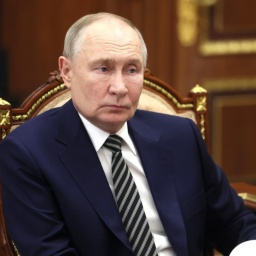 Russlands Präsident Vladimir Putin sitzt im Kreml und hört einem Gespräch zu