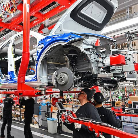 Mitarbeiter der Tesla Gigafactory Berlin Brandenburg arbeiten am 22.03.2022 an einer Fertigungslinie eines Elektrofahrzeuges vom Typ Model Y. (Quelle: dpa/Patrick Pleul)