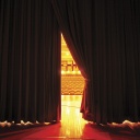 Blick durch einen Vorhang in einen Theatersaal