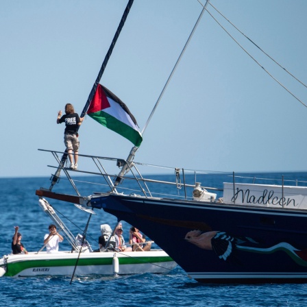 Greta Thunberg neben Palästina-Flagge auf einem Segelschiff