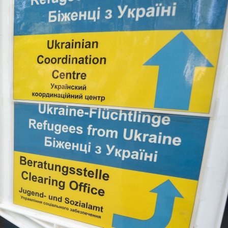 Besucher gehen an einem Hinweisschild der Initiative Ukrainian Coordination Center (UCC) am Eingang zum Amt für multikulturelle Angelegenheiten der Stadt Frankfurt am Main vorbei. Menschen aus der Ukraine wird hier vielfältige Hilfe angeboten.
