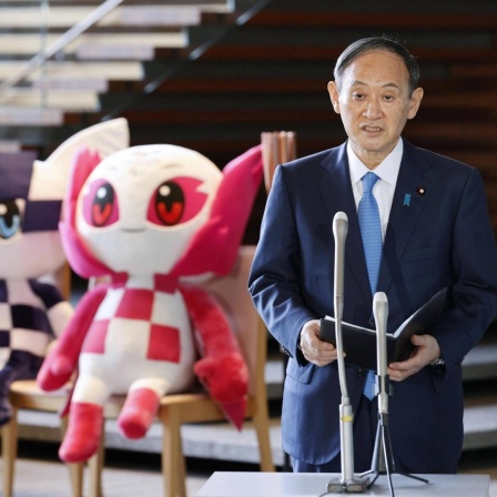 Tokyo Olympic torch relay Japanese Prime Minister Yoshihide Suga speaks to reporters at his office in Tokyo on March 25, 2021, alongside Tokyo 2020 Olympic and Paralympic mascots, Miraitowa and Someity. The torch relay for the Tokyo Games started the same