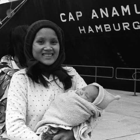 Eine junge Frau mit Kind steht vor demm Rettungsschiff &#034;Cap Anamur&#034;