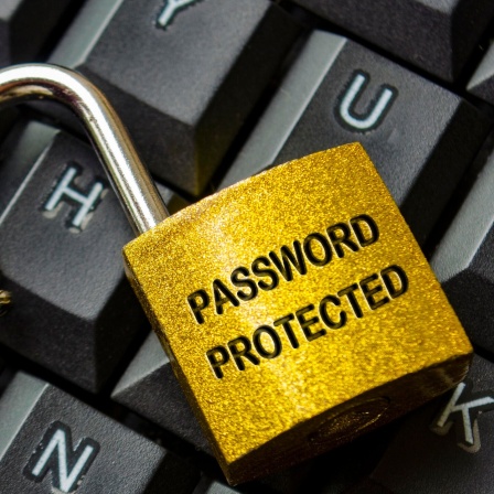 Top view of password protected text engraved on padlock with keyboard background