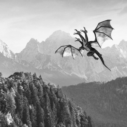 Eine schwarz-weiße Panorama-Aufnahme mit einem Schloss und einem dreiköpfigen Drachen, der durch den Himmel fliegt. 
